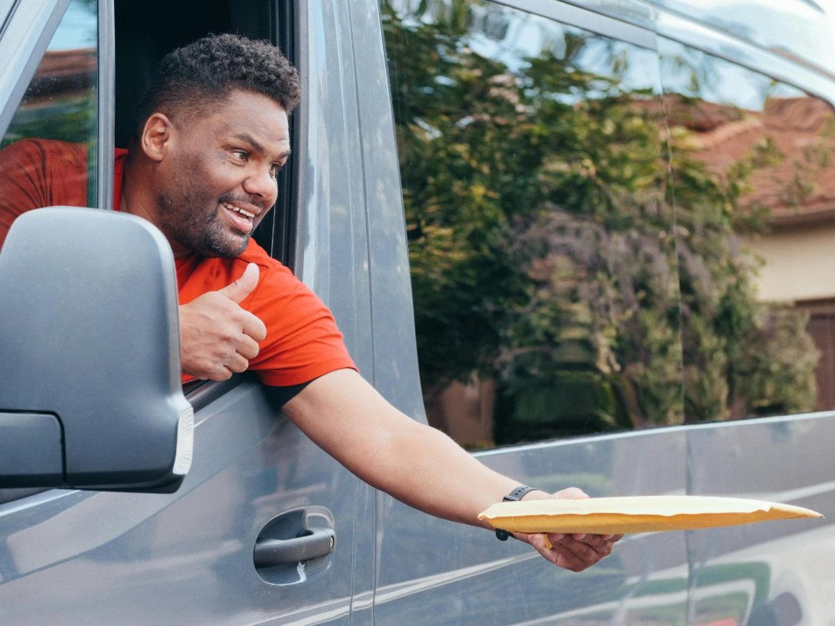 An e-commerce fulfillment specialist in San Diego tracking a forever stamp order on a dual-monitor dashboard, checking shipping updates for bulk 1,000ndnd-unit coils of USPS flag stamps.