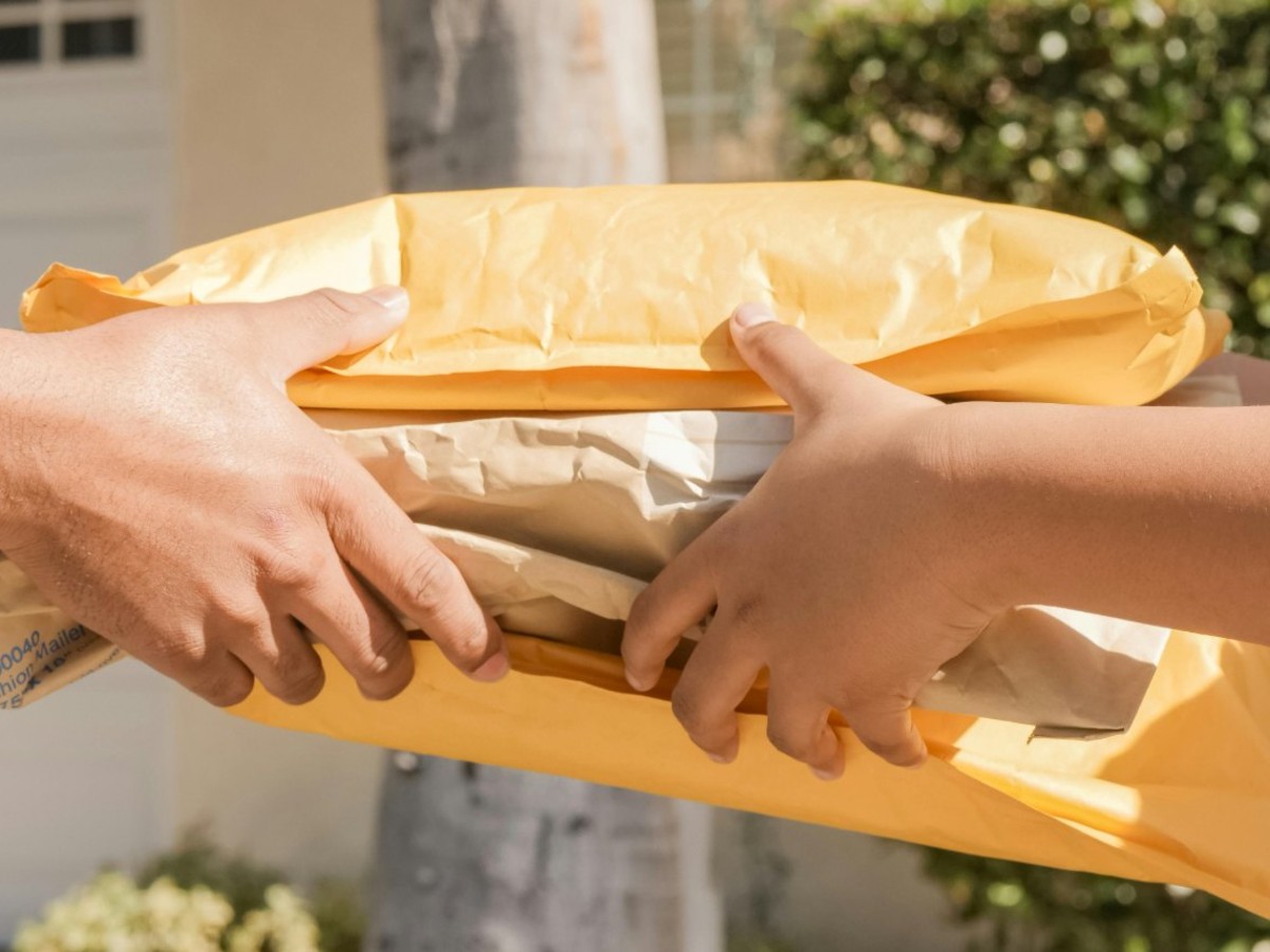 A straightforward logistics manager in a Dallas, TX, distribution center reviewing a pallet of surplus USPS flag forever stamp coils for corporate standardization.