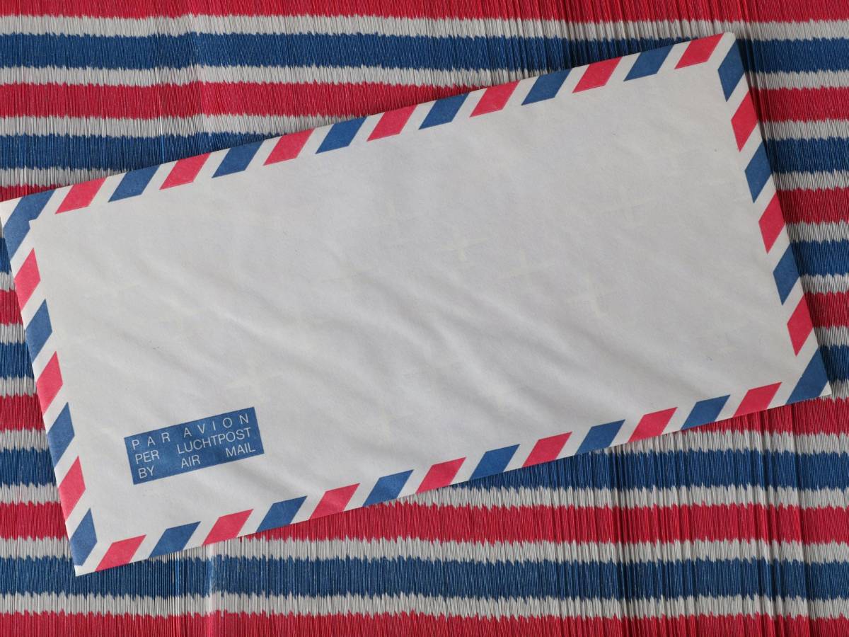 A traditional heritage site coordinator in Richmond, VA, auditing a roll of 2019 US Flag forever stamps next to historic archival documents.