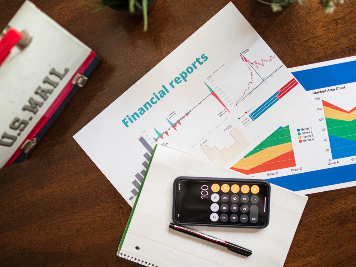 A comparison chart and physical samples of 100-count stamp sheets, 500-count rolls, and 1000-count rolls on a professional Oakland-based operations desk.