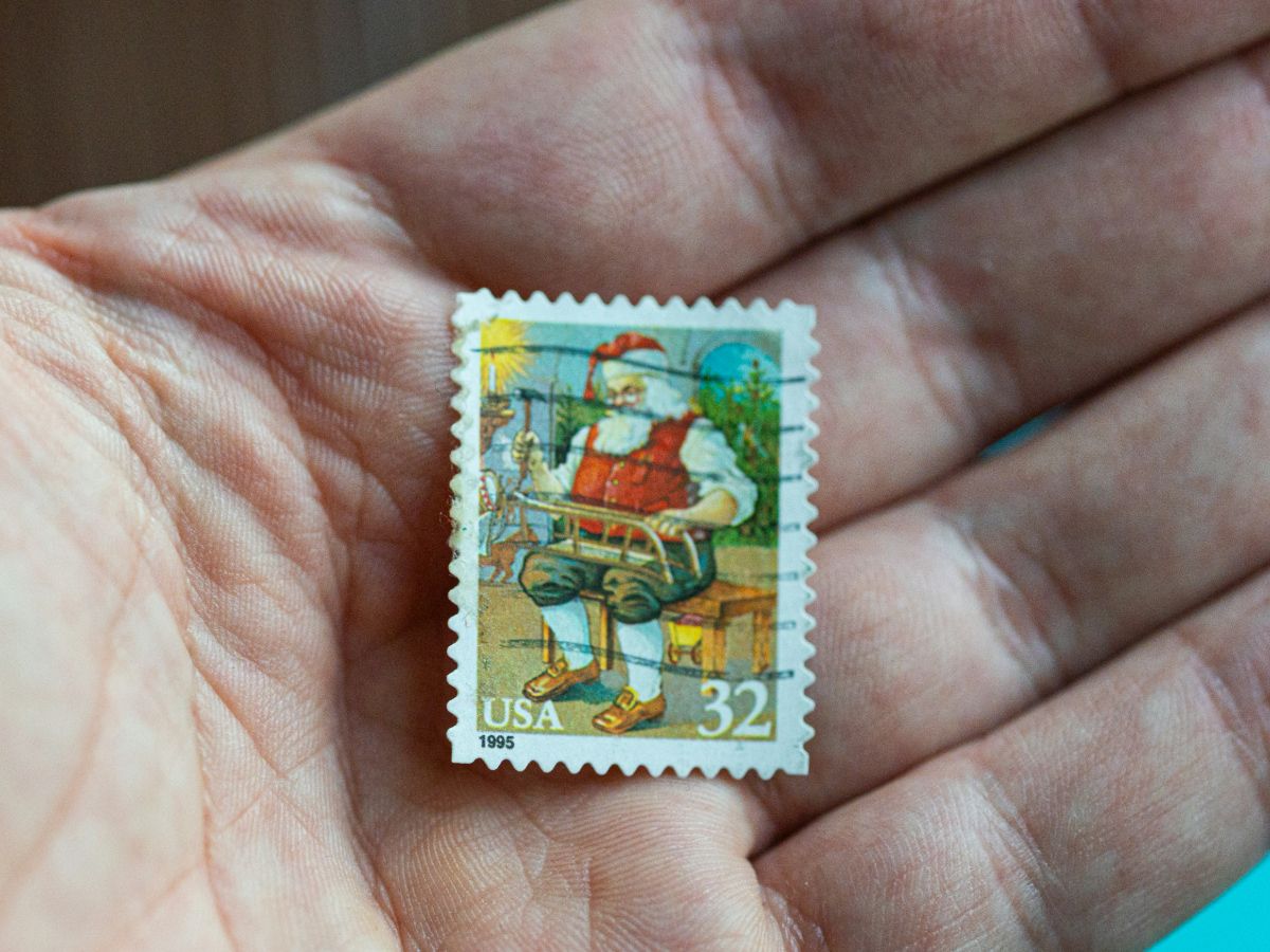 A non-profit director in a DC office verifying a batch of Forever stamps against a donor manifest during a morning audit.